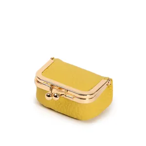 Mini yellow leather kiss-lock pouch detail, compact coin purse and jewelry storage box.