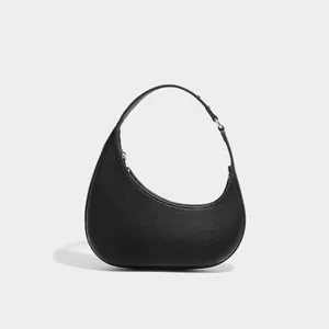Black leather crescent shoulder bag detail, minimalist hobo bag design with zipper closure.