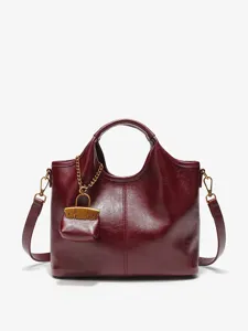 Burgundy leather handbag for women, elegant tote bag with chic mini pouch charm and strap.