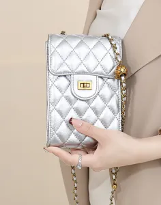 Silver quilted mini phone bag detail, featuring classic flap design and chic gold chain strap.
