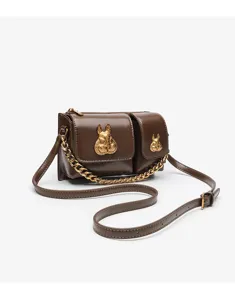 Detailed view of the dark brown chic crossbody bag featuring gold chain and rabbit metal decor.