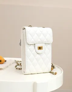 White quilted leather mini phone crossbody bag featuring vintage gold turn-lock and chain.