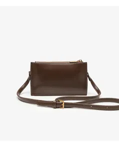 Dark brown leather crossbody bag detail, showing fine texture, metal zipper and adjustable strap.
