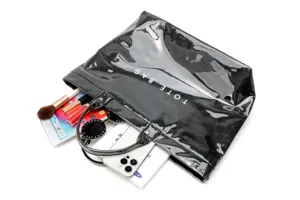 Black glossy waterproof tote bag large capacity commuter handbag with daily items display.