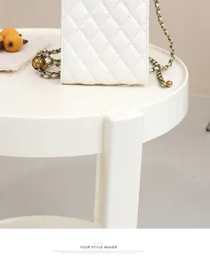 White quilted phone bag with chain strap and vintage metal ball, elegant mini crossbody bag.