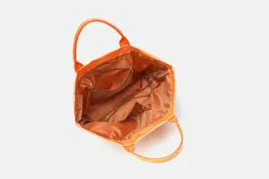 Orange tote bag interior view showing large main compartment and inner zipper pocket.