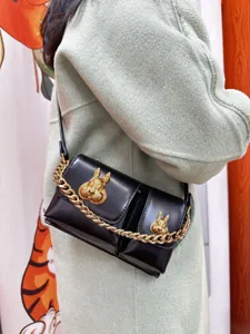 Black PU leather shoulder bag with gold chain and rabbit head ornaments for women daily fashion.