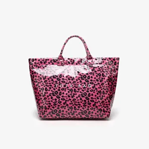 Pink leopard print tote bag detail showing glossy waterproof texture and front logo.