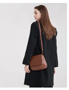 Classic brown saddle bag detail view, vintage leather crossbody purse for women autumn style.
