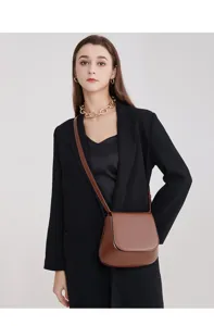 Classic brown saddle bag detail view showing elegant minimalist design and premium leather texture.