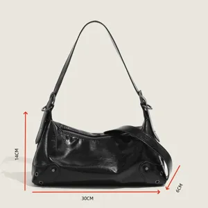 Detail view of black vintage motorcycle shoulder bag with metal studs and size dimensions.