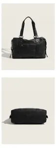 Detailed view of the black travel duffle bag, showing leather texture and double top handles.
