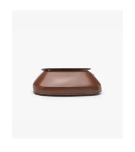 Brown leather saddle bag close-up detail showcasing fine stitching and smooth curved shape.