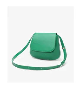 Green leather saddle bag detail, showcasing smooth texture, curved flap, and adjustable strap.