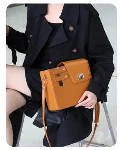 Detailed shot of the stylish brown shoulder bag with metal lock and strap, elegant design.