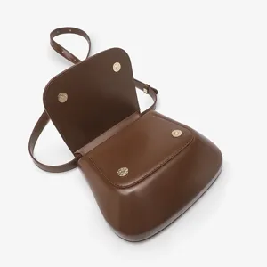 Classic brown leather saddle bag for women, elegant shoulder crossbody design with metal clasp.