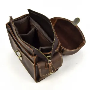 Vista dettagliata dei comparti interni e del design della cerniera della borsa fotografica in pelle.