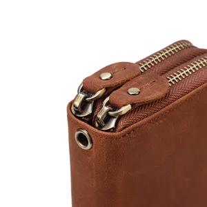 Primer plano de cartera de cuero marrón para hombre de alta calidad con cremalleras dobles y metal.