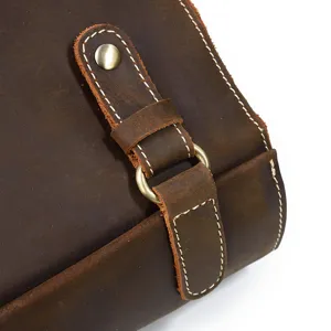 Close-up detail of vintage crazy horse leather backpack strap, hardware and stitching.