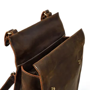 Close-up detail of vintage crazy horse leather backpack showing fine stitching and metal hardware.