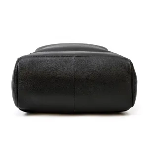 Close-up detail of the black leather backpack bottom, showing durable texture and fine stitching.