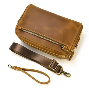 Vue rapprochée d'une pochette en cuir marron vintage avec des accessoires métalliques.