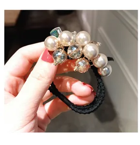 Gros plan de détail d'un élégant élastique à cheveux en perles et cristal facetté de style coréen.