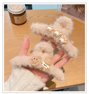 Detalle de pinza de pelo de peluche, accesorio de invierno suave con osito y carita.