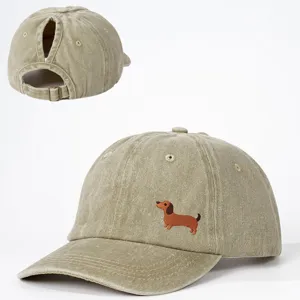 Detailansicht der gewaschenen khaki Ponytail Baseballkappe mit Dackel-Bestickung und Metallschnalle.