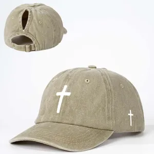 Casquette de baseball kaki lavé avec trou pour queue de cheval, imprimé croix blanche.