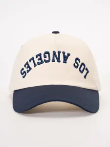 Vista detallada de la elegante gorra de béisbol bicolor con texto bordado de diseño.