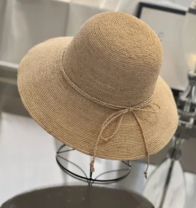 Detailed view of a woven straw sun hat featuring a wide brim and delicate braided bow tie.
