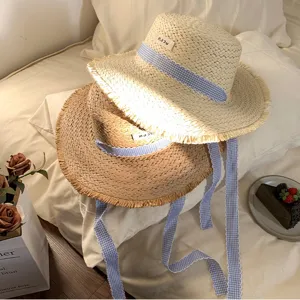 Chapeau de paille plat français avec long ruban et bord frangé pour la plage et les vacances d'été.