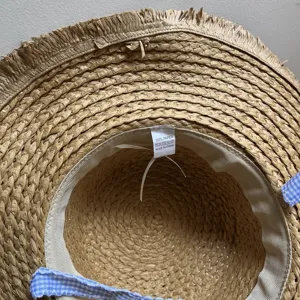 Gros plan sur l'intérieur d'un chapeau de paille avec texture tissée et étiquette.