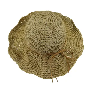 Vue de détail supérieure d'un chapeau de paille d'été avec un joli ruban nœud marron.