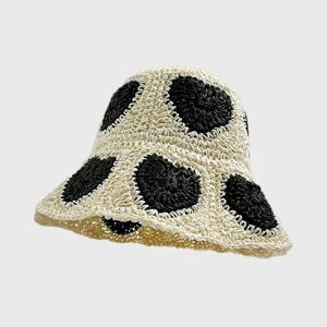 Detailansicht des handgearbeiteten Häkel-Bucket-Hats mit einzigartiger schwarzem Herzmuster Textur.