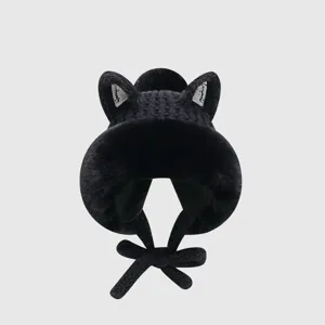 Detailed close-up view of the plush black knitted winter hat featuring cute cat ears and warm earflaps.