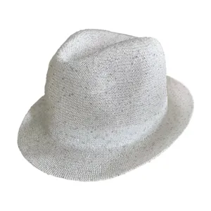 Primo piano di un cappello fedora bianco scintillante con dettagliata trama traforata.