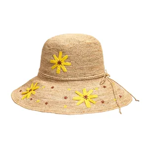 Handmade raffia sun hat detail, yellow floral decor, breathable summer beach protection.