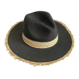 Close-up view of black and beige straw hat featuring trendy fringe brim and jazz top style.