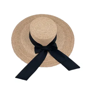 Chapeau de paille plat à large bord pour femme avec un nœud papillon noir pour l'été.