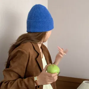Gros plan du bonnet d'hiver bleu élégant, texture douce tricotée portée en scène de vie.