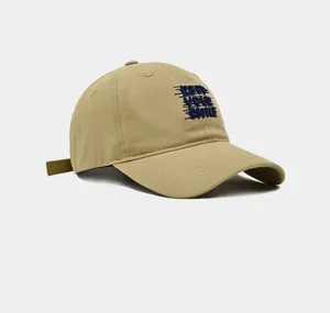 Vista en primer plano detallada de la gorra de béisbol caqui con texto frontal bordado.