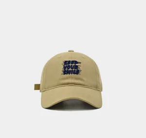 Vista de detalle de una gorra de beisbol kaki vintage con bordado azul texto keep smile.