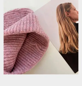 Confortable bonnet d'hiver en tricot côtelé rose, douce matière chaude gros plan.