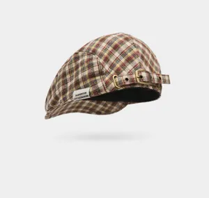 Vue détaillée de la casquette plate à carreaux, boucle en métal et étiquette de marque.