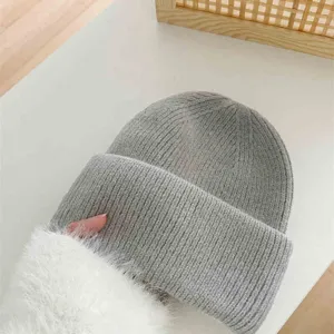 Gros plan sur les détails d'un bonnet en tricot gris, mélange de poils de lapin chaud.