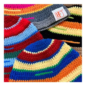 Close-up detail of colorful crochet knit beanie hats, handmade winter striped bucket cap.