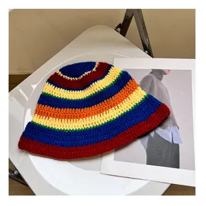 Close-up detail view of a colorful handmade crochet bucket hat with vibrant rainbow striped pattern.