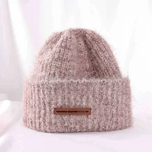 Closeup detail shot of the thick warm knit beanie hat in soft pink wool texture.